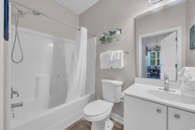 Bathroom featuring wood finished floors, toilet, vanity, baseboards, and shower / tub combo | Image 21