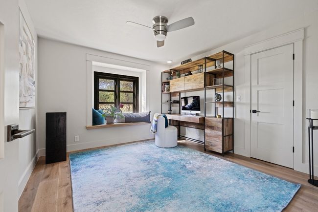 Unfurnished office/secondary guest room downstairs with wood finished floors and a ceiling fan | Image 34