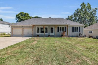 Single story home featuring a front lawn, a garage, and a porch | Image 1