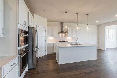 (Photo of similar home, finishes may vary) The kitchen features brand-new appliances, ample cabinetry, designer-selected countertops and a pantry for added storage space. | Image 1