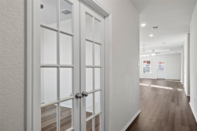 Entry corridor with dark laminate / wood-style floors and French doors leading to office space | Image 11