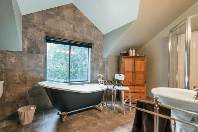 Full bathroom featuring a freestanding bath, tile walls, a shower stall, and vaulted ceiling | Image 28