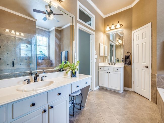 Full bath featuring ornamental molding, vanity, a shower stall, ceiling fan, and tile patterned floors | Image 21