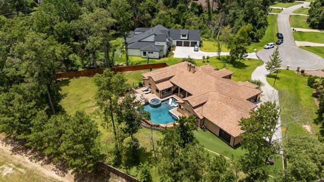 Lower right side of house shows rear exit garage door. This leads to additional outdoor living space featuring astroturf, seating area, and putting green. | Image 12