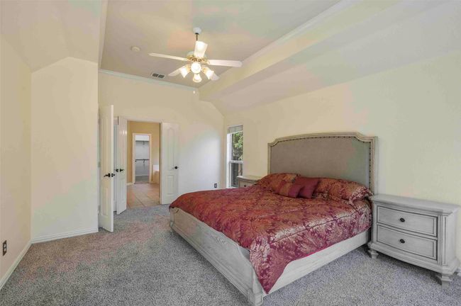 Carpeted bedroom with visible vents, ceiling fan, vaulted ceiling, and baseboards | Image 7