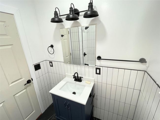 Bathroom with tile walls, vanity, and wainscoting | Image 9