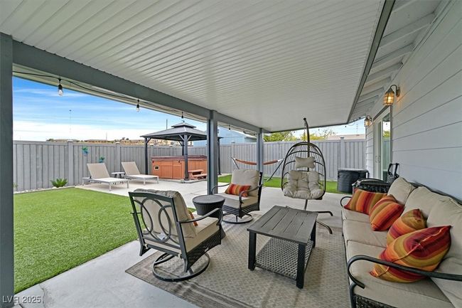 View of patio / terrace with a gazebo, an outdoor hangout area, a fenced backyard, and a hot tub | Image 27