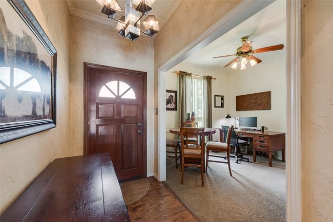 Foyer entrance featuring a chandelier, ornamental molding, wood finished floors, and ceiling fan | Image 5