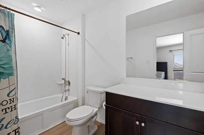Full bathroom featuring wood finished floors, toilet, vanity, ensuite bath, and shower / bath combo | Image 13