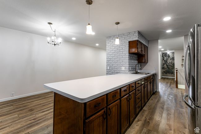 Kitchen featuring appliances with stainless steel finishes, a sink, dark wood finished floors, light countertops, and baseboards | Image 12