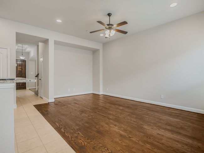 Unfurnished living room with a ceiling fan, wood finished floors, and recessed lighting | Image 11