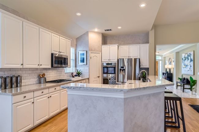 Kitchen featuring a pantry, and breakfast bar, opening to family room | Image 11