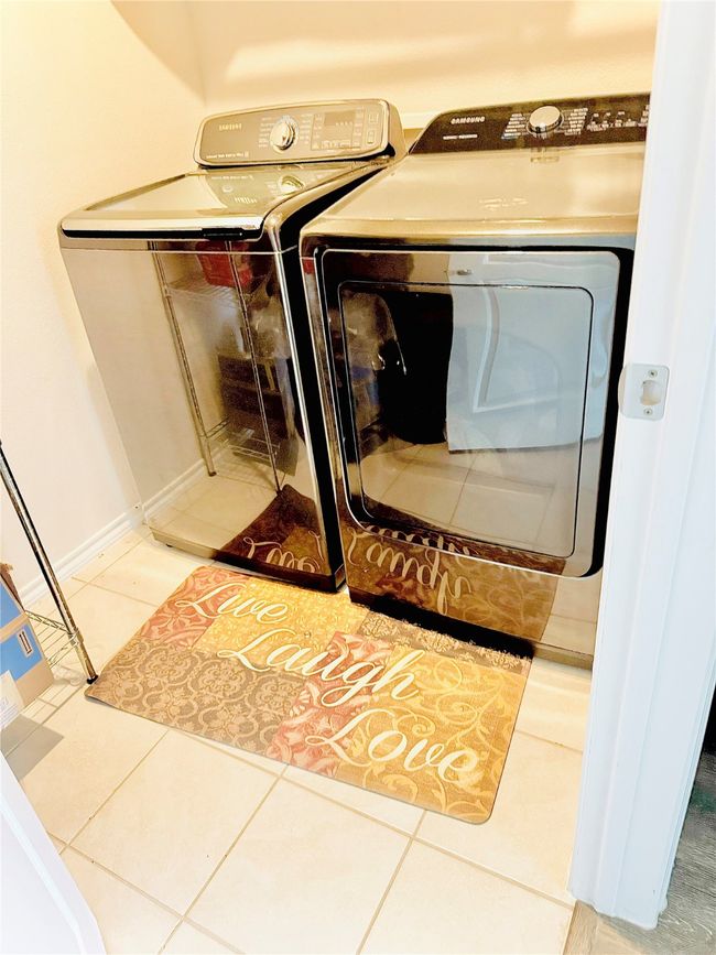 Laundry area featuring washer and clothes dryer and tile patterned flooring | Image 20