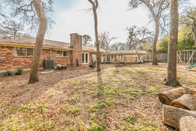 Back of property featuring a chimney, brick siding, a playground, and a sunroom | Image 23