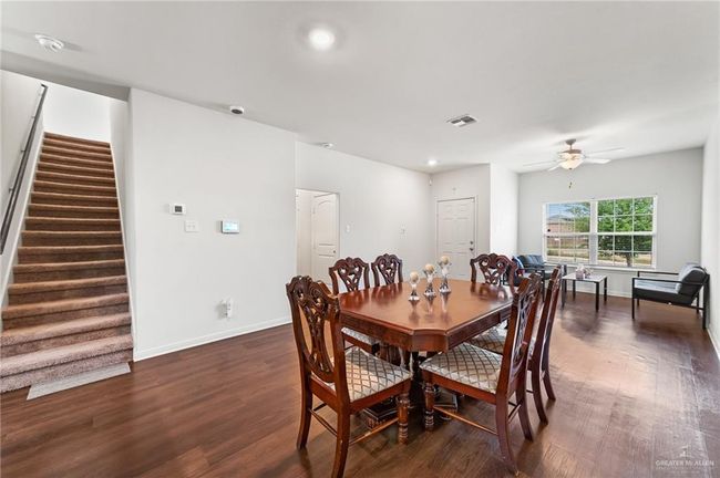 Dining room with a ceiling fan, stairs, dark wood-style floors, baseboards, and recessed lighting | Image 5