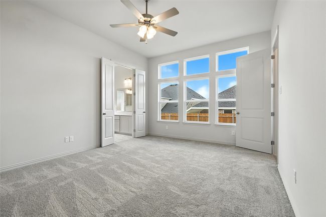 Unfurnished bedroom with carpet, connected bathroom, and ceiling fan | Image 18