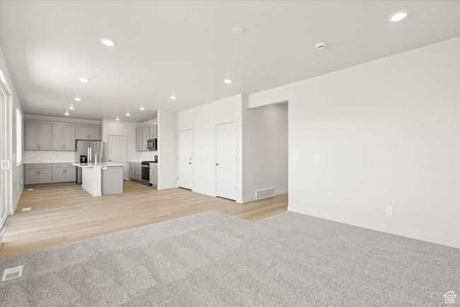 Unfurnished living room with recessed lighting, light wood finished floors, and light carpet | Image 13