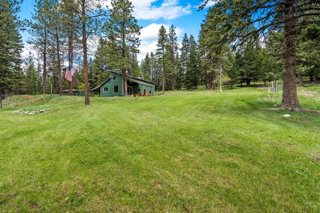 View of the gently sloped backyard leading up to the home, showcasing the exterior and outdoor space | Image 43