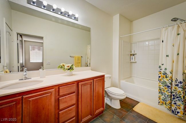 Bathroom featuring vanity, shower / tub combo, and tile patterned flooring | Image 22