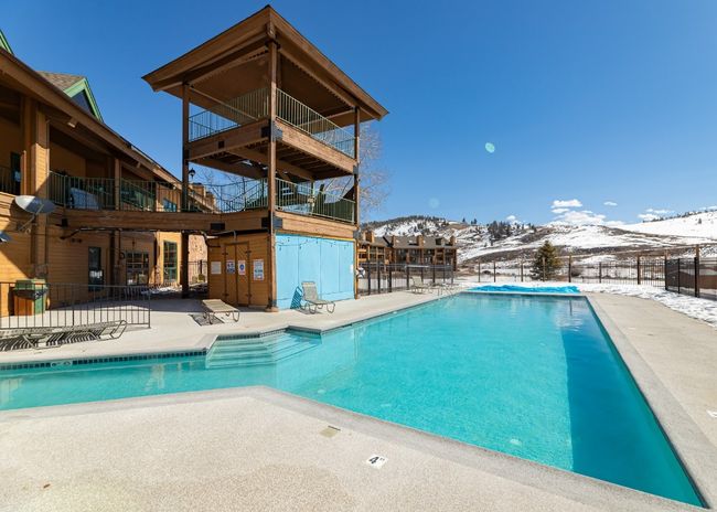 Snow covered pool featuring a patio area, a mountain view, and a community pool | Image 18