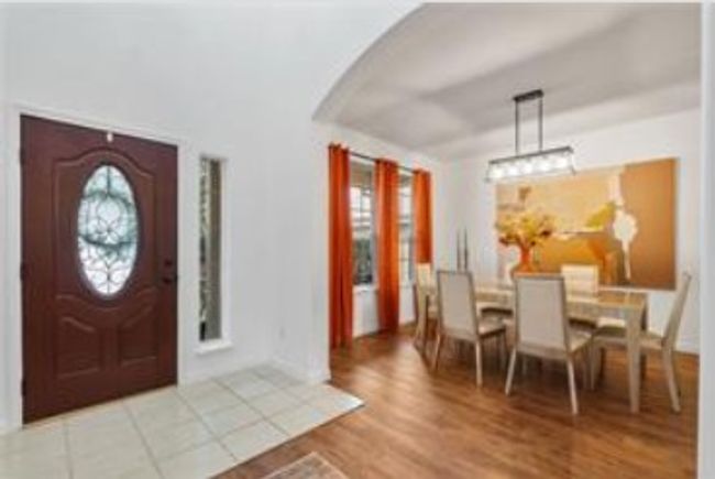Entrance foyer with arched walkways, a notable chandelier, wood finished floors, and baseboards | Image 6