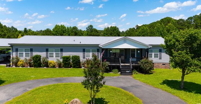 Ranch-style home with a porch, a front yard, a metal roof, and crawl space | Image 12