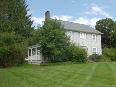 View of property exterior with a sunroom and a yard | Image 2