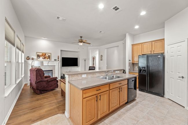 Kitchen featuring black appliances, a sink, ceiling fan, light countertops, and recessed lighting | Image 16