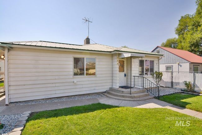 View of front of property featuring a chimney and a metal roof | Image 44