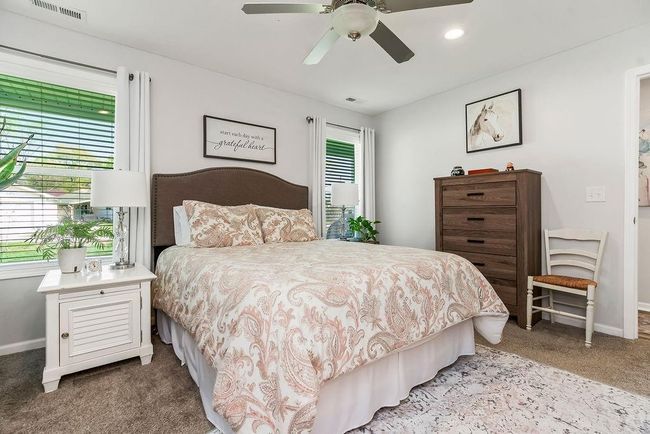 Bedroom featuring baseboards, a ceiling fan, visible vents, and carpet | Image 17