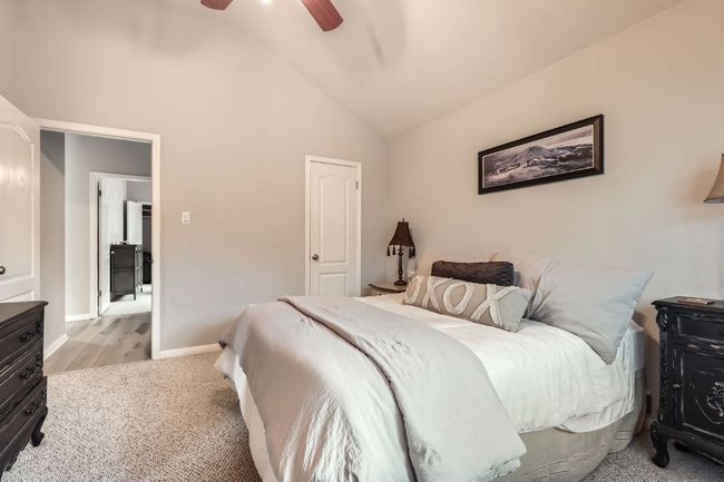 Bedroom with vaulted ceiling, light colored carpet, and ceiling fan | Image 15