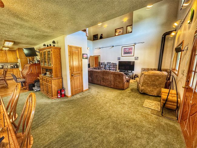 Carpeted living room featuring a wood stove and a textured ceiling | Image 19