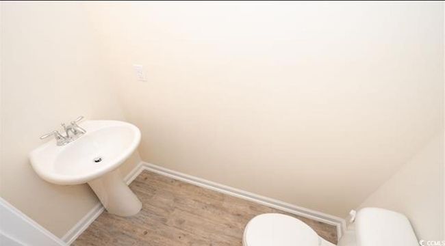 Bathroom with baseboards, toilet, and wood finished floors | Image 8