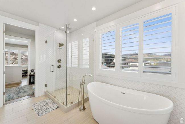 Bathroom featuring a freestanding tub, wood finished floors, a shower stall, and recessed lighting | Image 15