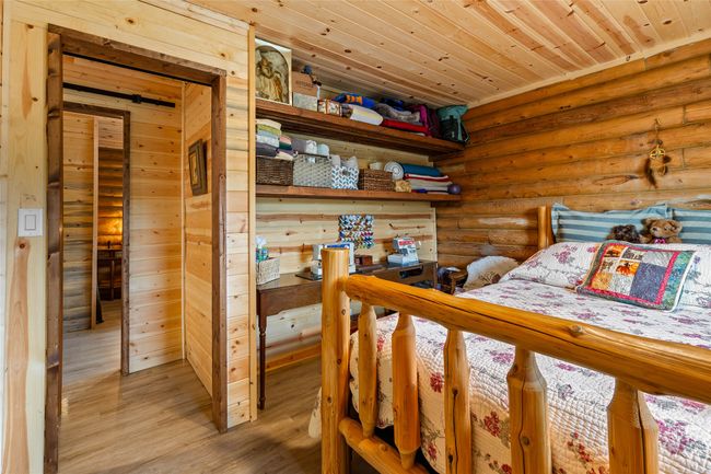 Bedroom with log walls, light wood finished floors, and wooden ceiling | Image 18