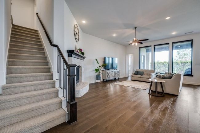 Living area featuring stairway, a ceiling fan, wood finished floors, recessed lighting, and baseboards | Image 8