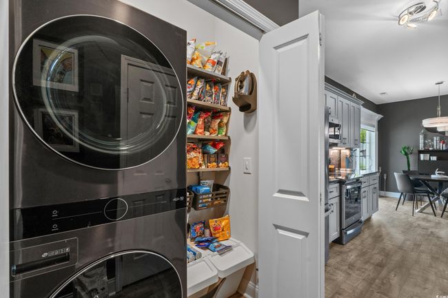 Laundry room with stacked washer / dryer and light wood-style flooring | Image 30