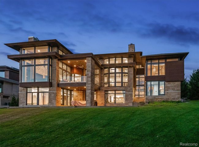 Rear view of house with a chimney, a lawn, and stone siding | Image 55