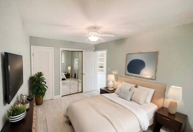 Bedroom with two closets, a ceiling fan, and wood finished floors | Image 24