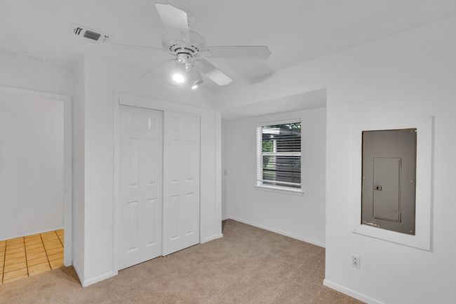 Unfurnished bedroom with visible vents, a closet, baseboards, electric panel, and carpet flooring | Image 17