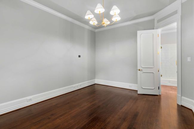Unfurnished room featuring a chandelier, dark wood-type flooring, and ornamental molding | Image 29