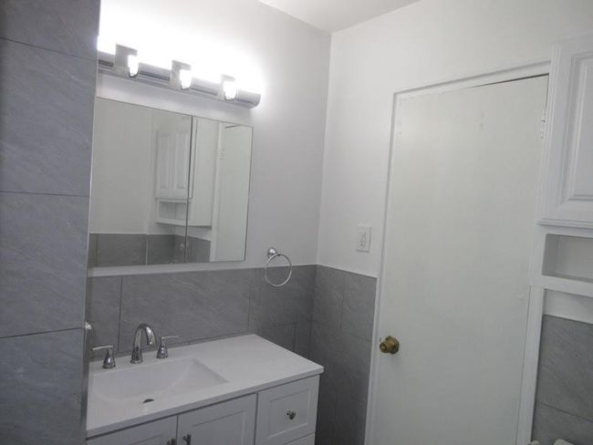 Bathroom with tile walls, a wainscoted wall, and vanity | Image 7