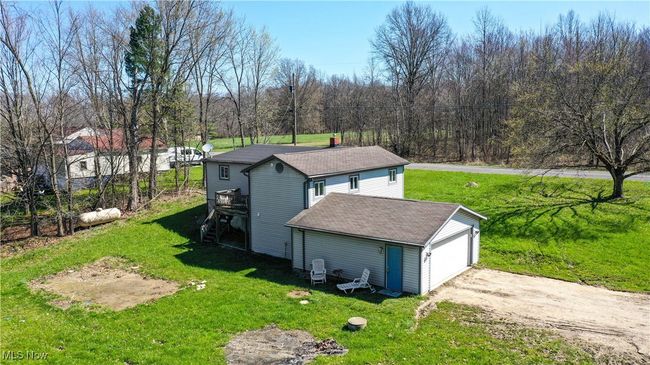 View of property exterior featuring a lawn and roof with shingles | Image 33