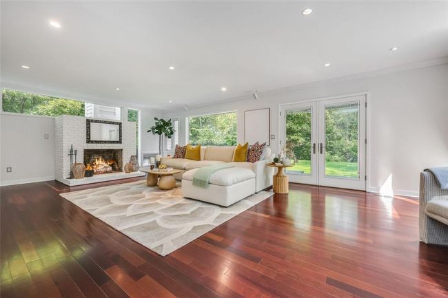 Living room featuring wood-type flooring, a fireplace, and crown molding | Image 13