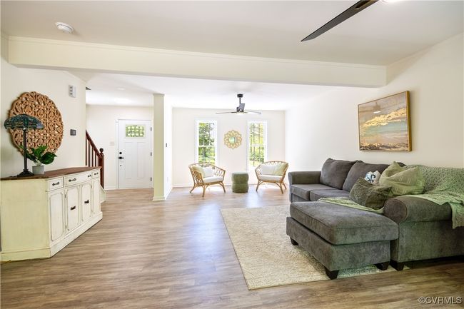 Living area featuring baseboards, wood finished floors, stairs, and ceiling fan | Image 12