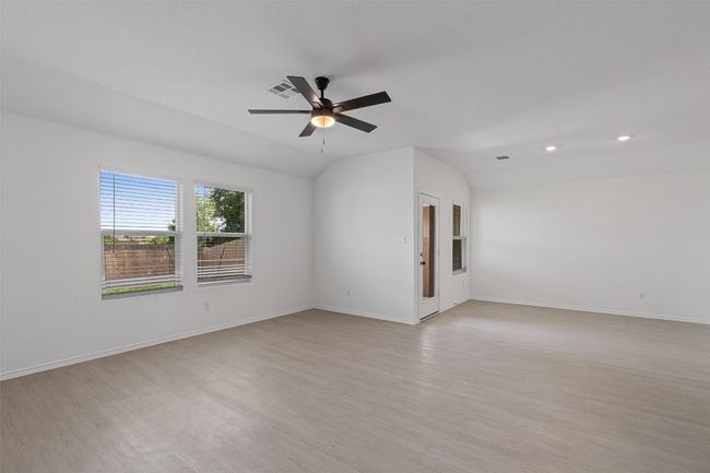 Unfurnished room with lofted ceiling, light wood-type flooring, a ceiling fan, and recessed lighting | Image 10