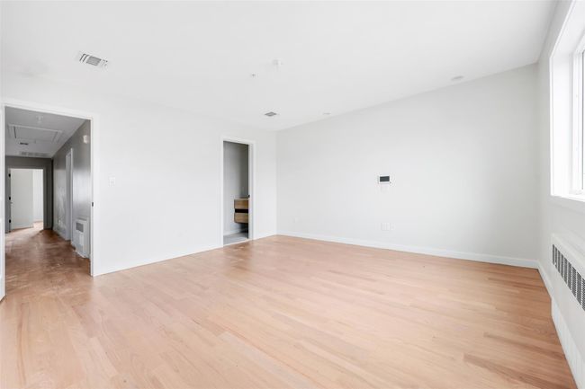 Spare room with radiator heating unit and light wood-type flooring | Image 46