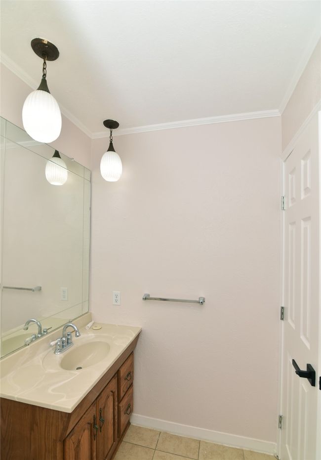 Bathroom featuring vanity, crown molding, baseboards, and tile patterned flooring | Image 24