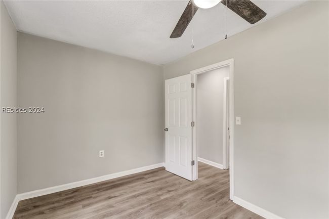 Unfurnished bedroom featuring hardwood / wood-style flooring and ceiling fan | Image 13