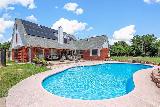 View of swimming pool featuring a lawn and a patio | Image 7